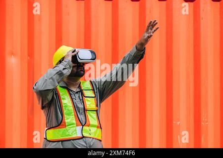 I lavoratori che utilizzano dispositivi con cuffie e auricolari VR Vision Pro Technology lavorano presso Container Yard Construction Site innovazione nel settore della logistica Foto Stock