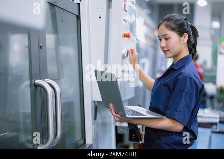 Giovani tecnici ingegneri lavoratrici lavoratrici che lavorano con macchine per tornio CNC in una moderna fabbrica dell'industria siderurgica Foto Stock