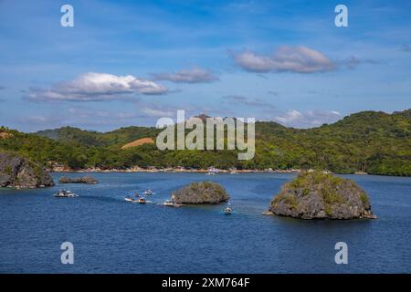 Le barche Bangka Outrigger Canoa Tour portano gli amanti dello snorkeling a siete Pecados, un gruppo di sette piccole isole vicino a Coron, Palawan, Filippine Foto Stock