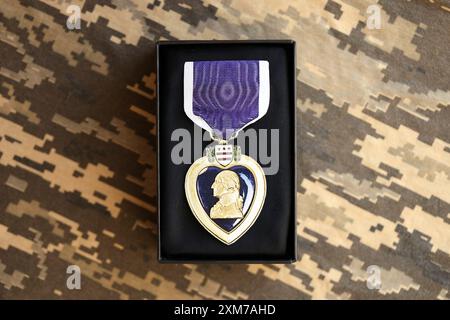 KIEV, UCRAINA - 10 LUGLIO 2024 US Purple Heart Medal. Medaglia di premio militare degli Stati Uniti con nastro e spilla. Primo piano di oggetti di scena fatti a mano in carta Foto Stock