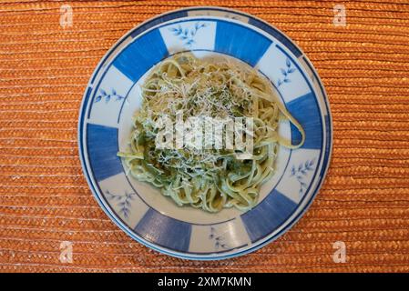 Pasto tipico italiano di prima portata: Spaghetti con salsa al pesto. A base di foglie di basilico fresco, parmigiano grattugiato e pinoli, con abbondante extra vi Foto Stock