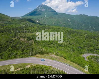 Rausu, Hokkaido: Veduta aerea di un'auto che guida sulla strada verso il vulcano del Monte Rausu nella penisola di Shiretoko in una soleggiata giornata estiva a Hokkaido in Foto Stock