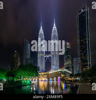 Una foto delle Torri Petronas, dello spettacolo delle fontane e delle fontane del KLCC Park e del centro commerciale Suria KLCC di notte. Foto Stock