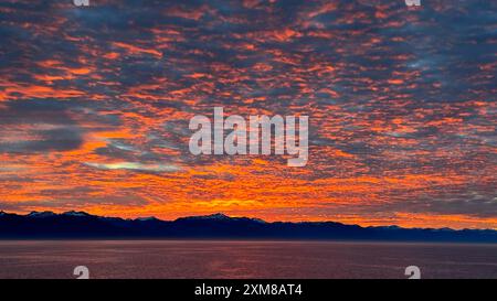 Fantastico tramonto sulle montagne dell'Alaska, visto dall'acqua vicino al parco nazionale di Glacier Bay Foto Stock