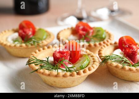 Stuzzichini deliziosi con salsicce affumicate secche, formaggio spalmabile e verdure sul tavolo, primo piano Foto Stock