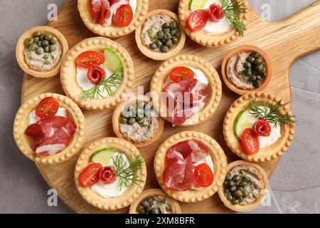 Stuzzichini deliziosi con jamon, pate e salsicce affumicate asciutte su un tavolo testurizzato grigio, vista dall'alto Foto Stock