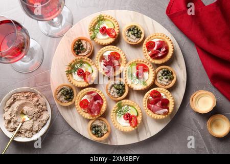 Deliziosi stuzzichini serviti su un tavolo con texture grigia, piatto Foto Stock