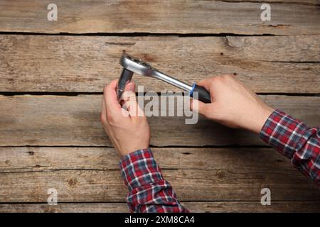 Meccanico automatico con chiave dinamometrica su tavola di legno, primo piano Foto Stock