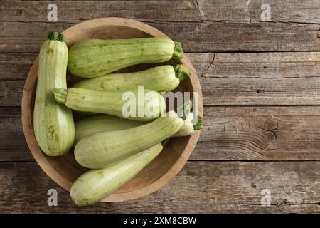 Zucchine verdi crude su tavolo in legno, vista dall'alto. Spazio per il testo Foto Stock