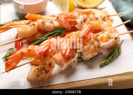 Spiedini con deliziosi gamberetti grigliati sul tavolo, primo piano Foto Stock