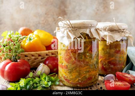 Cibo fermentato fatto in casa sano. Insalate di pomodori con verdure su un tavolo rustico. Economia domestica, conservazione del raccolto autunnale. Foto Stock