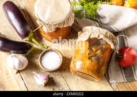 Cibo fermentato fatto in casa sano. Insalata di melanzane con verdure un tavolo rustico. Economia domestica, conservazione del raccolto autunnale. Foto Stock