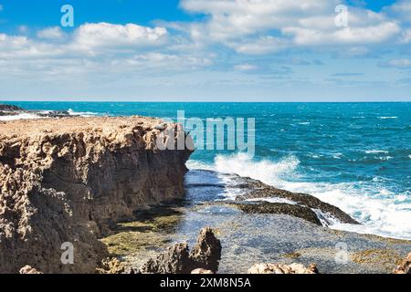 Onde che si infrangono su scogliere terrazzate nell'Oceano Indiano a Point Quobba, una parte remota della costa corallina dell'Australia Occidentale a sud di Carnarvon Foto Stock