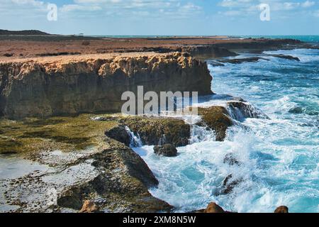 Enormi onde che si infrangono su spettacolari scogliere, a Point Quobba, una parte remota della costa corallina australiana occidentale a sud di Carnarvon Foto Stock