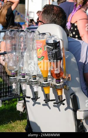 Lulworth, Dorset, Regno Unito. 26 luglio 2024. Uomo in mobilità scooter con ottica da pub attaccato ascoltare musica al festival familiare Camp Bestival, 26 luglio 2024, credito: Dawn Fletcher-Park/Alamy Live News Foto Stock