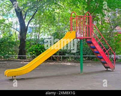 Il gioioso scivolo giallo per bambini e bambini nel parco giochi residenziale giapponese Foto Stock