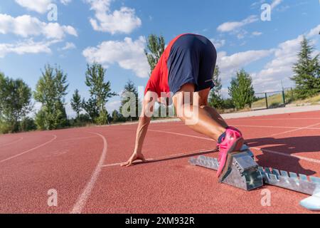 Stadio, uomo che corre e inizia il blocco di atleta su una pista da corsa e arena per lo sprint Foto Stock