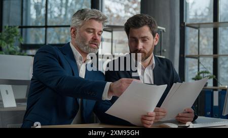 Dirigenti uomini caucasici uomini d'affari team partner commerciali colleghi che lavorano su statistiche finanziarie analizzando i dati nel report che discute progetto Foto Stock