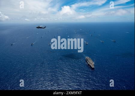 Un elicottero MH-60S Seahawk, attaccato ai “Black Knights” dell’Helicopter Sea Combat Squadron (HSC) 4, vola su navi multinazionali che navigano in formazione, al largo delle Hawaii durante l’esercitazione Rim of the Pacific (RIMPAC) 2024, 22 luglio. Ventinove nazioni, 40 navi di superficie, tre sottomarini, 14 forze terrestri nazionali, più di 150 aerei e 25.000 personale partecipano al RIMPAC nelle e intorno alle isole Hawaii, dal giugno 27 al agosto 1. Il RIMPAC, il più grande esercizio marittimo internazionale al mondo, offre un'opportunità di formazione unica, promuovendo e sostenendo al contempo relazioni di cooperazione Foto Stock