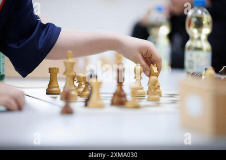 Primo piano di una mano che afferra un pezzo in una partita a scacchi Foto Stock