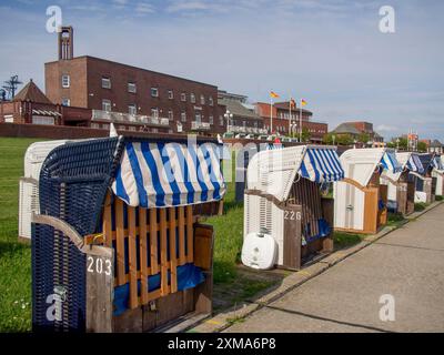 Fila di sdraio sul lungomare con posti a sedere numerati ed edifici sullo sfondo, wilhelmshaven, germania Foto Stock