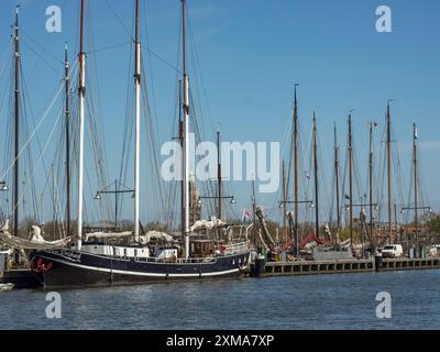 Barche a vela al tramonto nel porto, stormo di alberi contro un cielo blu, atmosfera tranquilla e tranquilla, enkhuizen, paesi bassi Foto Stock