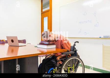 Vista laterale foto orizzontale con spazio di copia di un uomo con paralisi cerebrale utilizzando un tablet digitale che lavora in coworking Foto Stock