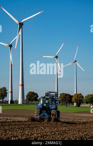 Agricoltore che lavora nei campi, con un trattore, un parco eolico sopra il villaggio di Lichtenau, autoproclamata città energetica, distretto di Paderborn, OWL, A North Foto Stock