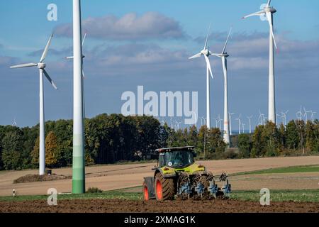 Agricoltore che lavora nei campi, con un trattore, un parco eolico sopra il villaggio di Lichtenau, autoproclamata città energetica, distretto di Paderborn, OWL, A North Foto Stock