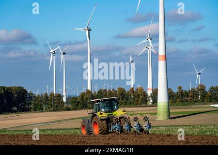 Agricoltore che lavora nei campi, con un trattore, un parco eolico sopra il villaggio di Lichtenau, autoproclamata città energetica, distretto di Paderborn, OWL, A North Foto Stock