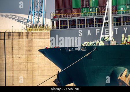 I serbatoi del terminale di importazione GNL per il gas naturale liquefatto nel porto marittimo di Rotterdam, rimorchiatori portuali portano il cargo container Ever Globe al suo ormeggio Foto Stock