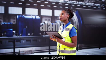 African Engineer Woman che controlla la struttura industriale. Ispezione OSHA Foto Stock