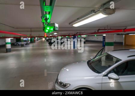 Parcheggi sotterranei, parcheggi multipiano, lampade rosse o verdi sul soffitto, mostrano ai conducenti se un posto auto è libero o occupato, e quindi Foto Stock