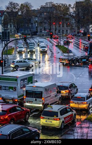 Tempo piovoso, traffico stradale, incrocio, luci di veicoli su strada bagnata, semafori, luci di coda, fari, immagine simbolica Foto Stock