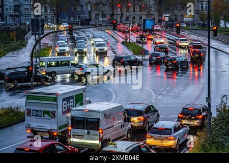 Tempo piovoso, traffico stradale, incrocio, luci di veicoli su strada bagnata, semafori, luci di coda, fari, immagine simbolica Foto Stock