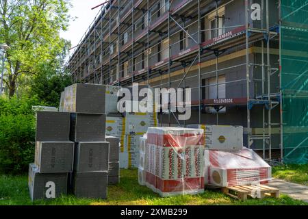 Ristrutturazione energetica di un condominio, isolamento termico, materiali da costruzione, materiali isolanti conservati di fronte al cantiere Foto Stock