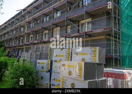 Ristrutturazione energetica di un condominio, isolamento termico, materiali da costruzione, materiali isolanti conservati di fronte al cantiere Foto Stock