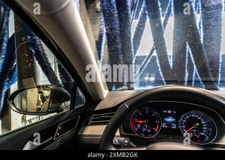 Auto in un autolavaggio automatico, tunnel di autolavaggio, asciugatura, con aria calda e panni in tessuto rotanti Foto Stock