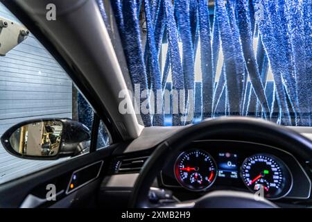 Auto in un autolavaggio automatico, tunnel di autolavaggio, asciugatura, con aria calda e panni in tessuto rotanti Foto Stock