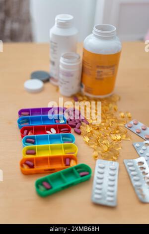 Medicinali di diversi tipi e colori con pillbox per organizzare l'assunzione di medicinali Foto Stock