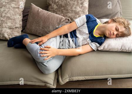 I dolori crescenti nei bambini, ragazzo di 10 anni, hanno dolore alla gamba, immagine simbolica Foto Stock