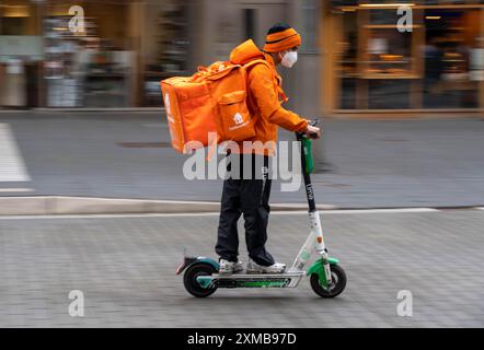 Servizio di consegna Lieferando.de, corriere con e-scooter nel centro della città, Rathenaustrasse, a Bochum, Renania settentrionale-Vestfalia Germania Foto Stock