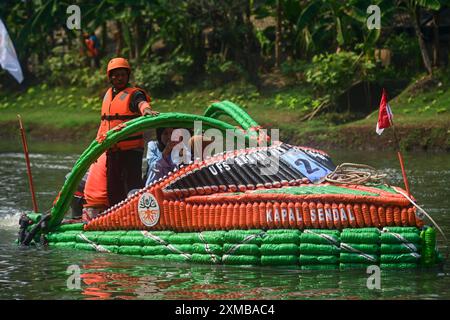 Giacarta, Indonesia. 27 luglio 2024. Una barca fatta di bottiglie di plastica naviga nel fiume Banjir Kanal Timur a Giacarta, Indonesia, 27 luglio 2024. Trentadue barche di plastica di scarto e di varie forme hanno partecipato a una parata di barche nel fiume Banjir Kanal Timur a Giacarta, Indonesia, il 27 luglio. Organizzato dalle agenzie idriche locali in occasione della giornata nazionale dei fiumi dell'Indonesia, l'evento è quello di invitare le persone a proteggere i fiumi e riciclare i rifiuti di plastica. Crediti: Zulkarnain/Xinhua/Alamy Live News Foto Stock