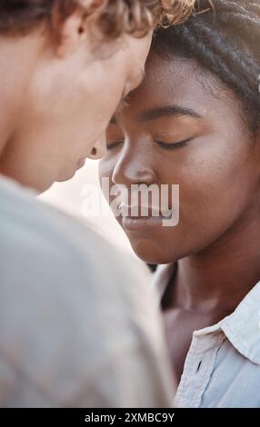 Rilassati, interrazziale e coppia con cura per l'amore, abbracciati e legati insieme in vacanza in California. Intimità, uomo e donna in relazione Foto Stock