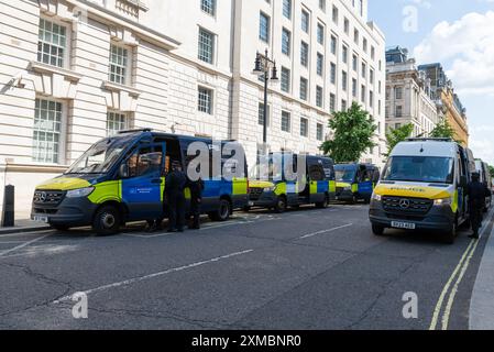 Westminster, Londra, Regno Unito. 27 luglio 2024. I sostenitori di Tommy Robinson si riuniscono nello Strand presso la Royal Courts of Justice per una marcia di protesta verso Trafalgar Square. I temi della protesta includono l'immigrazione, e una protesta avversaria organizzata da Stand Up to Racism si sta dirigendo verso la vicina Whitehall con 1000 agenti di polizia in servizio per scoraggiare gli scontri. Le unità di polizia stanno costruendo la loro presenza. Furgoni al largo di Whitehall Foto Stock