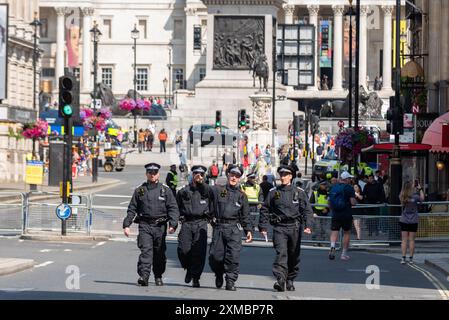 Westminster, Londra, Regno Unito. 27 luglio 2024. I sostenitori di Tommy Robinson si riuniscono nello Strand presso la Royal Courts of Justice per una marcia di protesta verso Trafalgar Square. I temi della protesta includono l'immigrazione, e una protesta avversaria organizzata da Stand Up to Racism si sta dirigendo verso la vicina Whitehall con 1000 agenti di polizia in servizio per scoraggiare gli scontri. Le unità di polizia stanno costruendo la loro presenza. Agenti chiusi a Whitehall Foto Stock