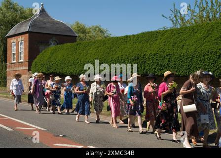 Nether Stowey Female Friendly Society; The Womens Walk il giorno del Club, camminano fino alla tomba nella chiesa di St Marys del loro fondatore, l'uomo d'affari locale Tom Poole. Le donne indossano i loro migliori abiti estivi e cappelli estivi, tutte portano un posey di fiori. Nether Stowey, Somerset, Inghilterra 21 giugno 2014. HOMER SYKES DEGLI ANNI '2010 DEL REGNO UNITO Foto Stock