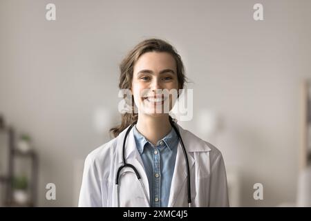 Donna laureata in medicina, pediatra in cappotto bianco in posa sul posto di lavoro Foto Stock