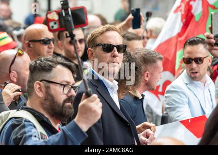 Westminster, Londra, Regno Unito. 27 luglio 2024. I sostenitori di Tommy Robinson si riunirono nello Strand presso la Royal Courts of Justice per una marcia di protesta verso Trafalgar Square. I temi della protesta includono l'immigrazione, e una protesta avversaria organizzata da Stand Up to Racism si sta dirigendo verso la vicina Whitehall con 1000 agenti di polizia in servizio per scoraggiare gli scontri. Laurence Fox ha partecipato Foto Stock