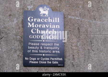 Gracehill, Irlanda del Nord - 26 luglio 2024: L'insediamento storico della Chiesa Morava vince lo status di patrimonio mondiale dell'UNESCO. Terra di sepoltura segno di acri di Dio. Foto Stock